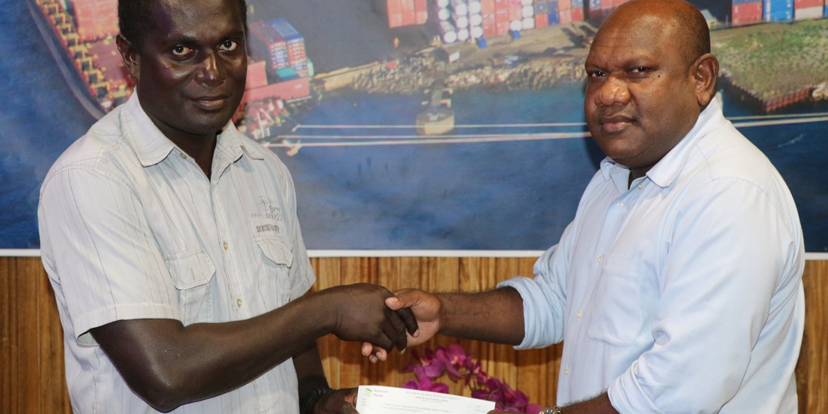 Solomon Ports Chief Financial Officer Mr.Georg Rausi handing over the cheque to Choiseul Bay PSS Principal, Mr. Murray Rotoava.