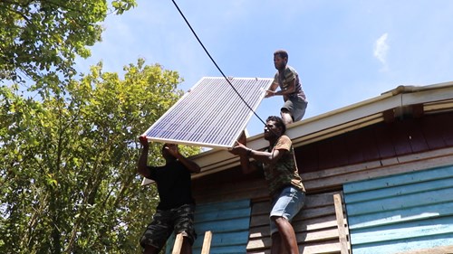 Villagers of Madili, Western Province, installing solar panels donated for their school classrooms, donated by SIPA.